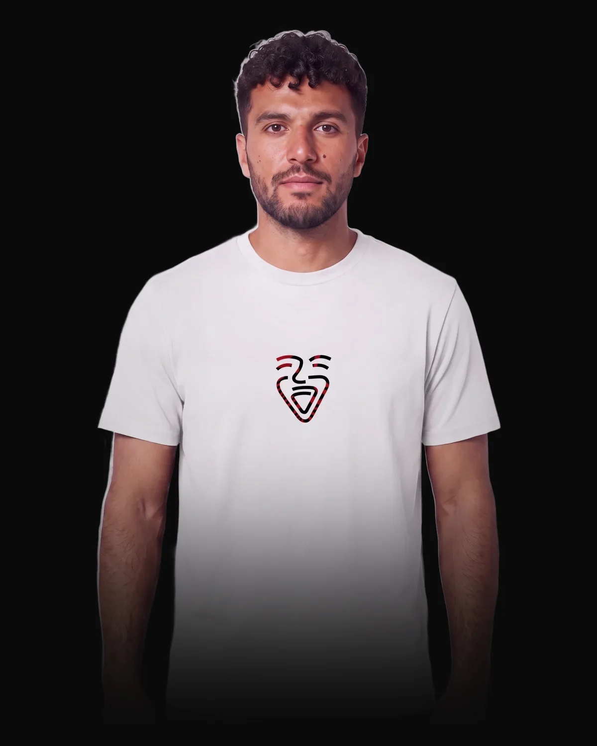 Man in a white OneFam shirt, the mark with the Albanian double-headed eagle on the chest, looking calmly into the camera